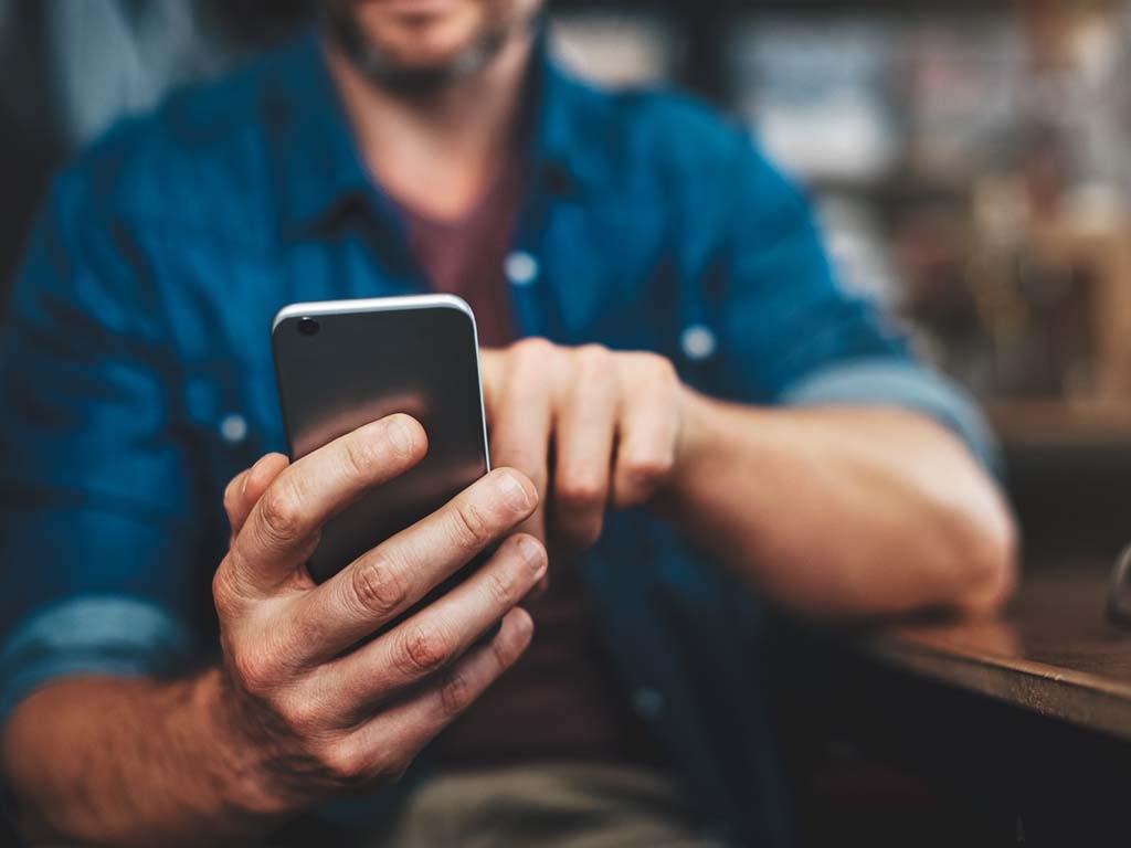 Person sitting at a desk using their phone