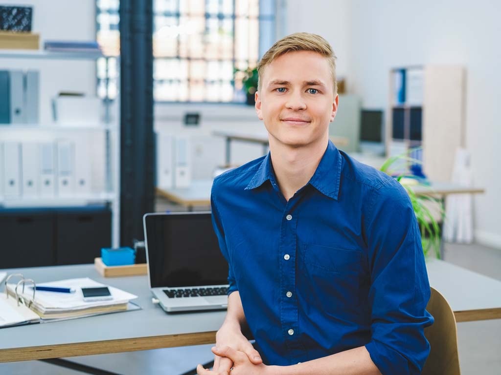 Smiling young businessman at his desk